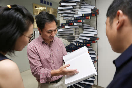 Scientist He Jiankui shows "The Human Genome", a book he edited, at his company Direct Genomics in Shenzhen, Guangdong province, China August 4, 2016. REUTERS/Stringer