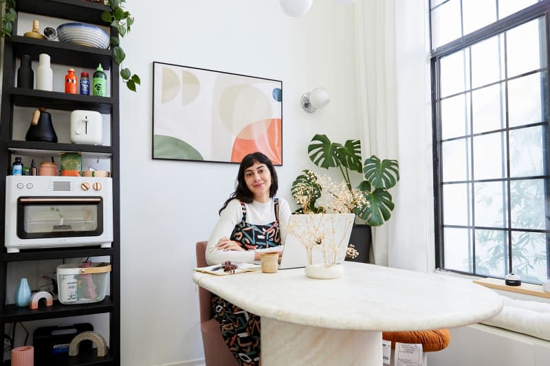 Dweller sitting at computer at dining room table.