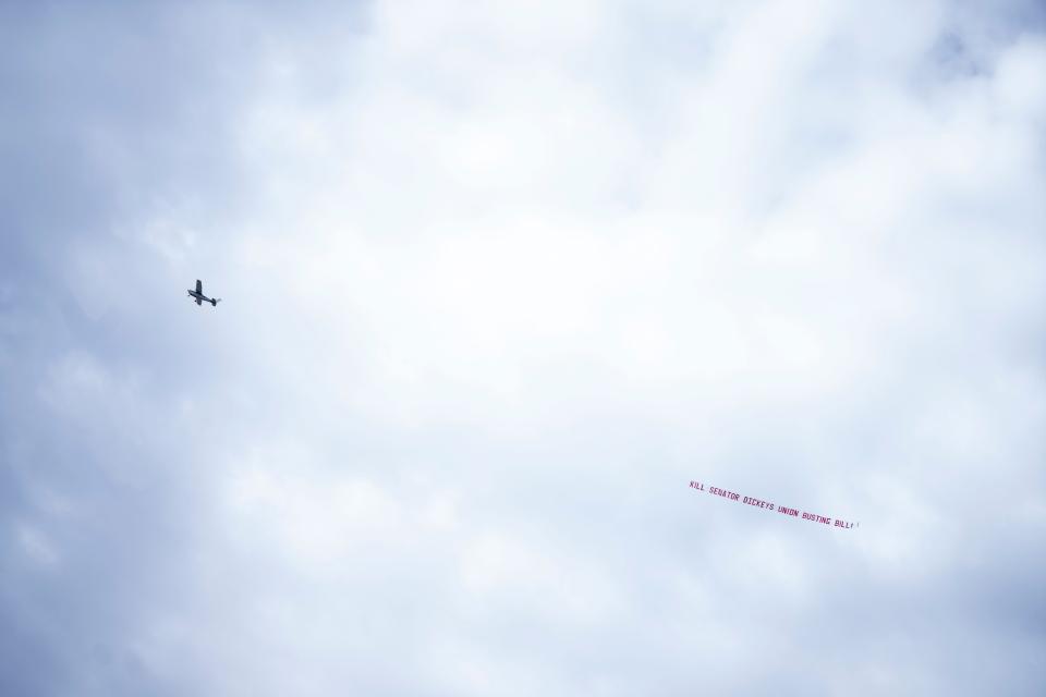 A plane pulls a banner that reads "Kill Senator Dickey's union busting bill" as part of a Teamsters Local 238 demonstration at the Iowa Capitol on Wednesday