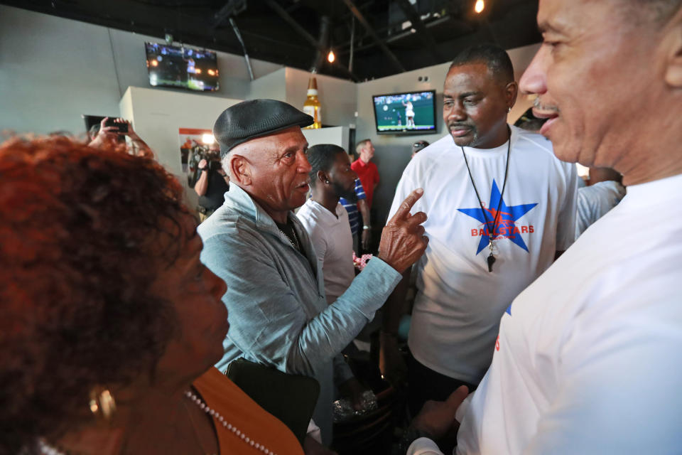 Eddie Odom, second from left, grandfather of tennis player Coco Gauff, and his sister Daisy Odom, left, chat with patrons after watching Gauff play at Wimbledon from the family-owned Paradise Sports Lounge, Monday, July 8, 2019, in Delray Beach, Fla. Former No. 1 Simona Halep defeated the 15-year-old American 6-3, 6-3. (AP Photo/Wilfredo Lee)