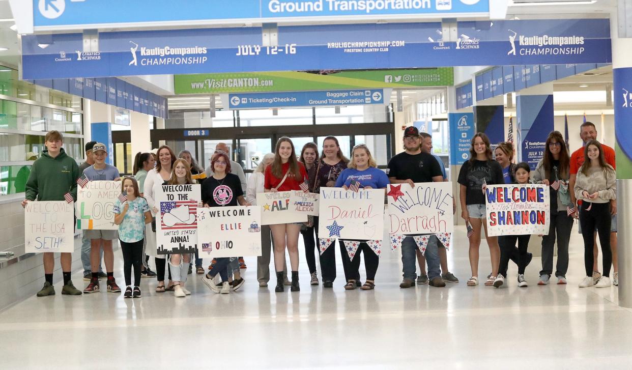 Host families wait with signs for the arrival of Ulster Project participants on Monday, June 26, 2023, at Akron-Canton Airport.