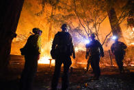 FILE - In this Aug. 21, 2020, file photo, firefighters make a stand in the backyard of a home in front of the advancing CZU August Lightning Complex Fire in Boulder Creek, Calif. Two unusual weather phenomena combined to create some of the most destructive wildfires the West Coast states have seen in modern times. (AP Photo/Marcio Jose Sanchez, File)