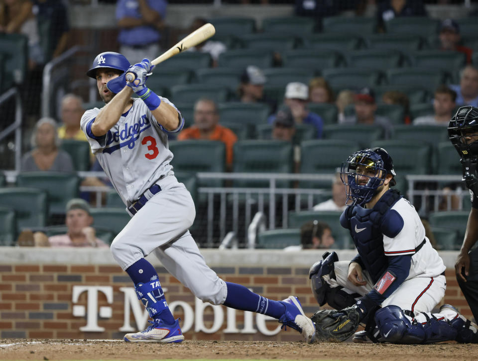 Los Angeles Dodgers' Chris Taylor hits an RBI double, scoring his team's first run during the eleventh inning of a baseball game against the Atlanta Braves on Sunday, June 26, 2022, in Atlanta. The Dodgers won 5-3. (AP Photo/Bob Andres)