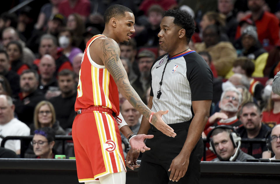 Atlanta Hawks guard Dejounte Murray, left, speaks with referee Mitchell Ervin, right, after being called for a foul during the second half of an NBA basketball game against the Portland Trail Blazers in Portland, Ore., Monday, Jan. 30, 2023. The Blazers won 129-125. (AP Photo/Steve Dykes)