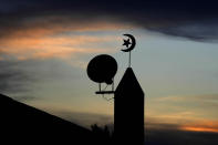 The sun sets behind an Islamic star and crescent at the Al-Shamal stadium in Al-Ruwais, Qatar, Tuesday, Nov. 29, 2022. (AP Photo/Matthias Schrader)