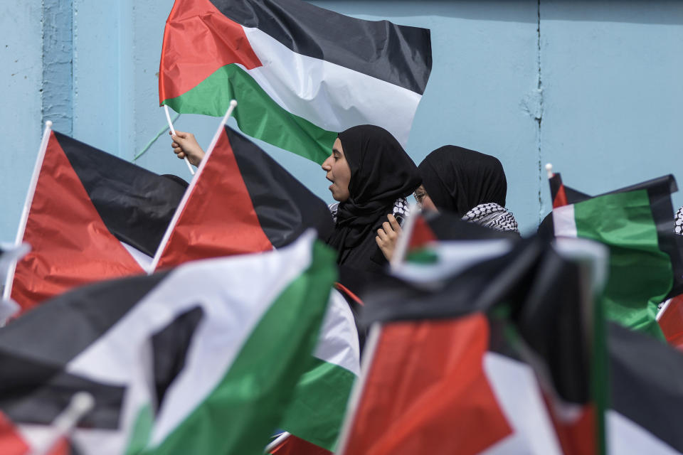 Protesters wave Palestinian flags during a sit-in in solidarity with the Palestinian people in Gaza in front of UNRWA office in Beirut, Lebanon, Thursday, April 18, 2024. Hundreds of Palestinian refugees protested Thursday outside the offices of the U.N. agency for Palestinian refugees in Beirut, expressing solidarity with fellow Palestinians in the Gaza Strip. (AP Photo/Hassan Ammar)