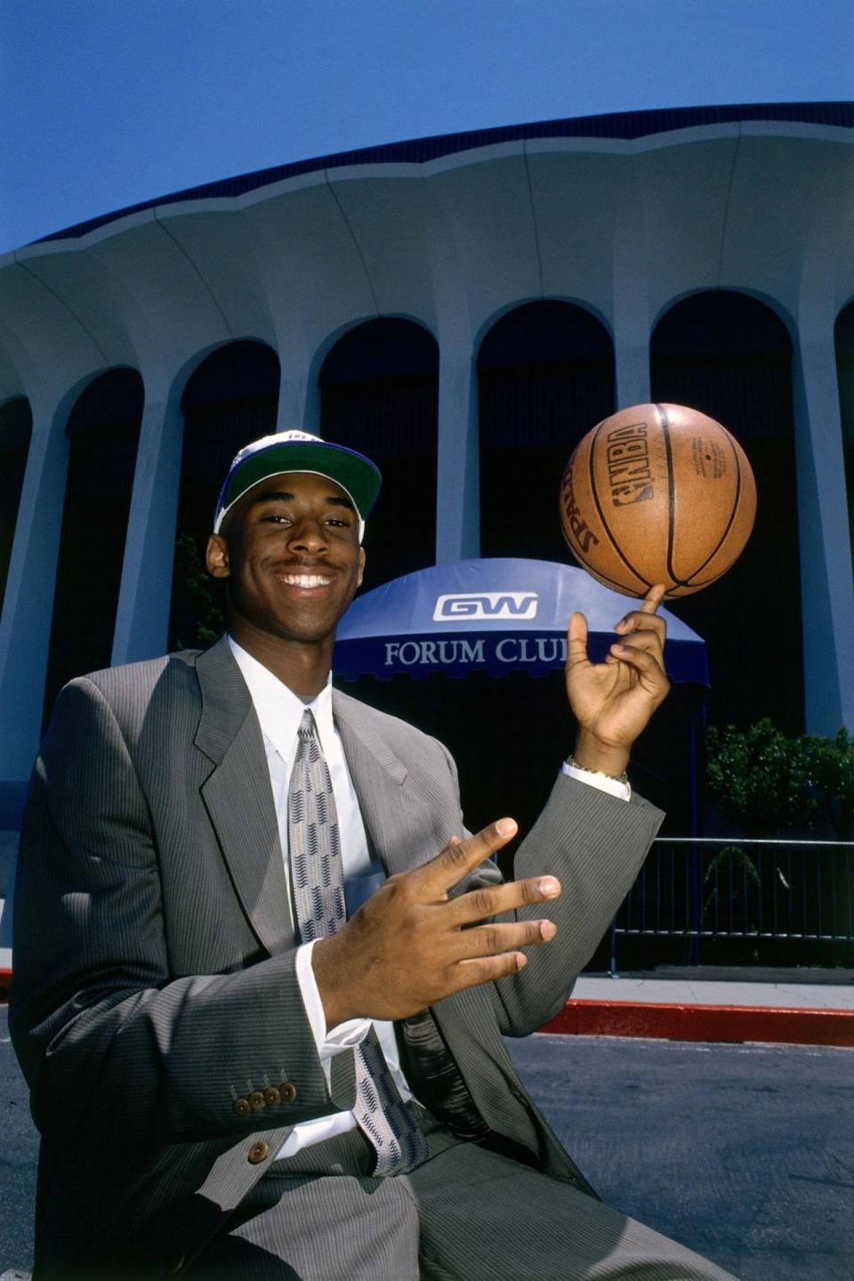 Kobe takes one of his first photos as a Los Angeles Laker, after being traded from the Charlotte Hornets. We appreciate his retro-print tie and ball cap. (Photo: Getty Images)