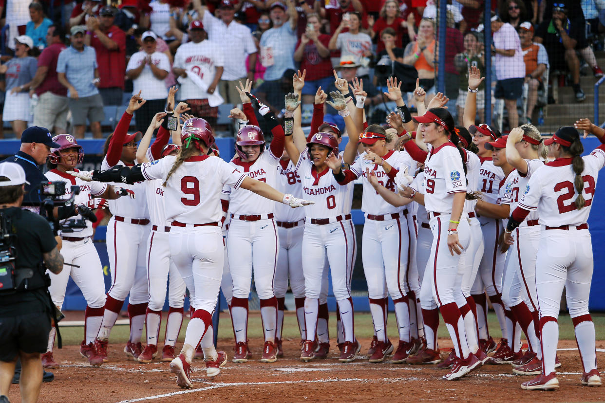 Oklahoma's Kinzie Hansen is greeted by her teammates after hitting one of three Sooners home runs on Wednesday. (Brian Bahr/Getty Images)