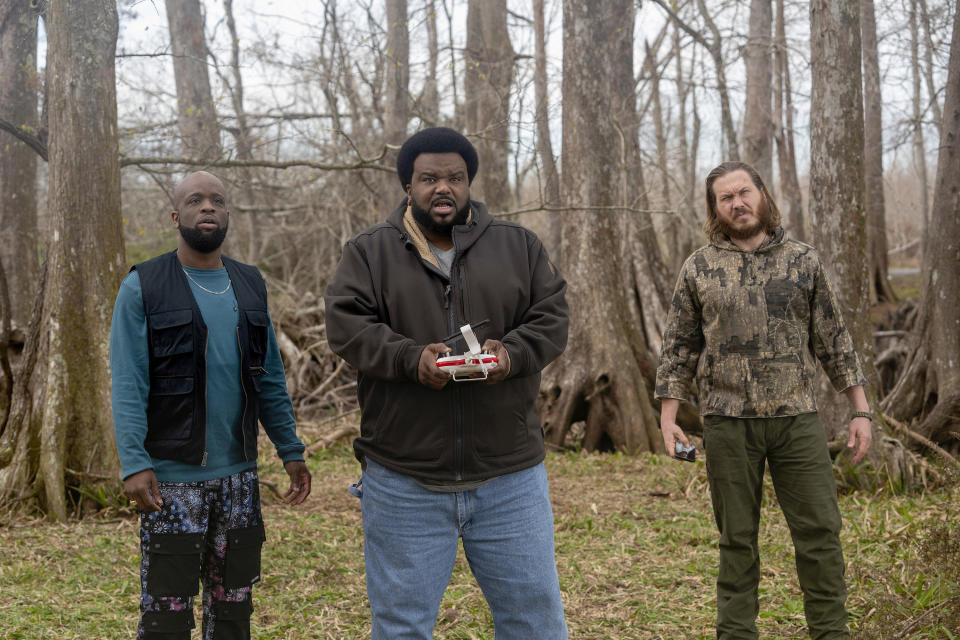 three men standing by the woods