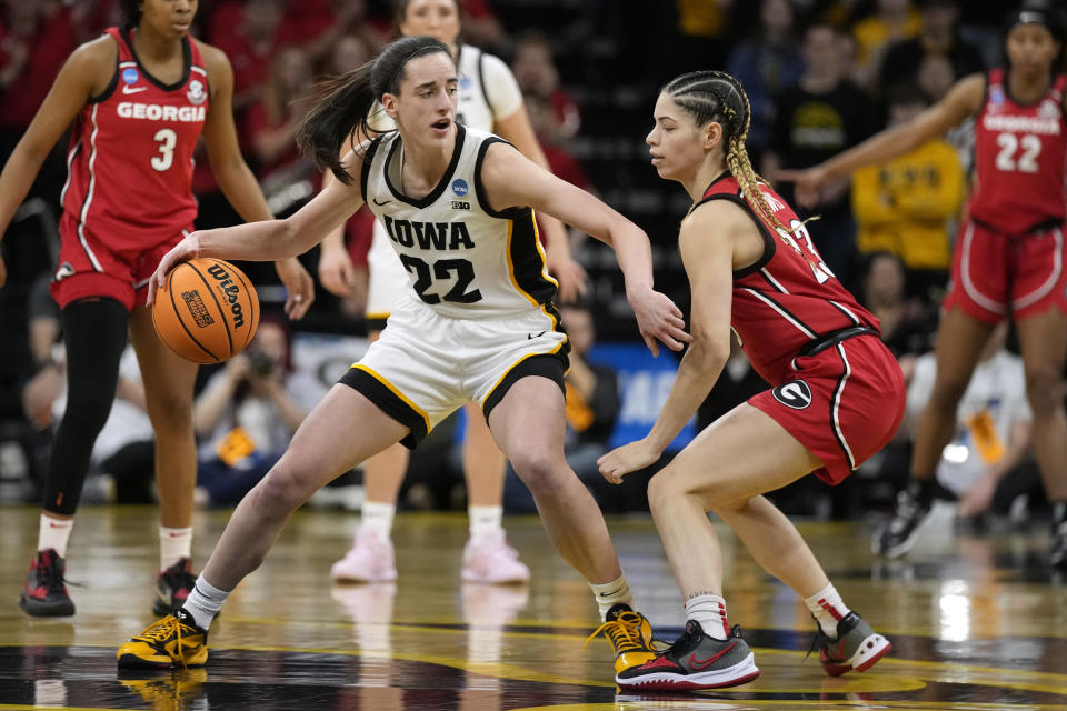 Iowa guard Caitlin Clark (22) drives around Georgia guard Alisha Lewis (23) in the first half of a second-round college basketball game in the NCAA Tournament, Sunday, March 19, 2023, in Iowa City, Iowa. (AP Photo/Charlie Neibergall)