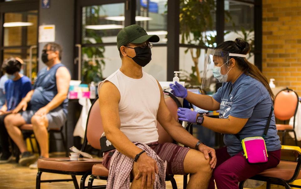 A man wearing a face mask receives a dose of the COVID-19 vaccine at a vaccination clinic in Mel Lastman Square in Toronto, Canada, on July 24, 2021. The City of Toronto kicked off a weekend-long vaccination clinic here on Saturday, welcoming walk-ins to anyone aged 12 and older for the COVID-19 vaccinations. (Photo by Zou Zheng/Xinhua via Getty Images)
