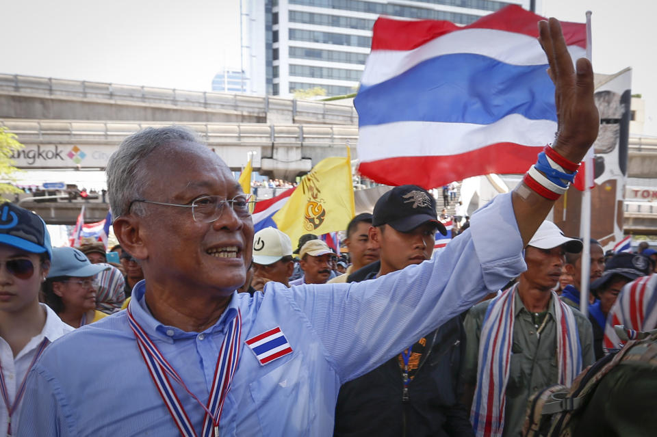 Anti-government protest leader Suthep Thaugsuban waves to supporters as the protesters move away from a month-long occupation of the city's main park and march to the prime minister's office compound in Bangkok, Thailand, Monday, May 12, 2014. The battle for who holds Thailand's seat of power took on a new twist Monday as Suthep planned to set up his office at the vacated Government House while the country's new caretaker leader worked from a makeshift, suburban outpost. (AP Photo/Vincent Thian)