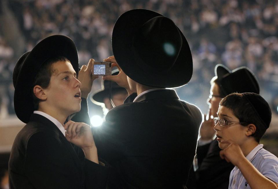 Orthodox Jewish boys stand together at MetLife stadium in East Rutherford, N.J, Wednesday, Aug. 1, 2012, during the celebration Siyum HaShas. The Siyum HaShas, marks the completion of the Daf Yomi, or daily reading and study of one page of the 2,711 page book. The cycle takes about 7½ years to finish.This is the 12th put on by Agudath Israel of America, an Orthodox Jewish organization based in New York. Organizers say this year's will be, by far, the largest one yet. More than 90,000 tickets have been sold, and faithful will gather at about 100 locations worldwide to watch the celebration. (AP Photo/Mel Evans)