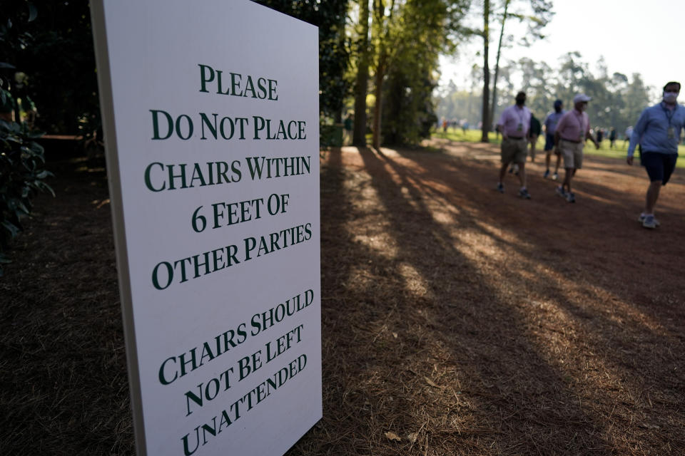 A sign posted on the course urges patrons to social distance during a practice round for the Masters golf tournament on Tuesday, April 6, 2021, in Augusta, Ga. (AP Photo/David J. Phillip)