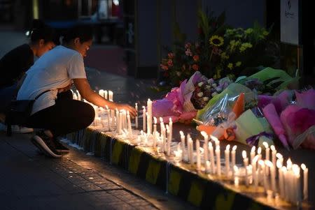 Employees light candles during a memorial for those killed in a casino fire at Resorts World in Pasay City, Metro Manila, Philippines June 2, 2017. REUTERS/Dondi Tawatao