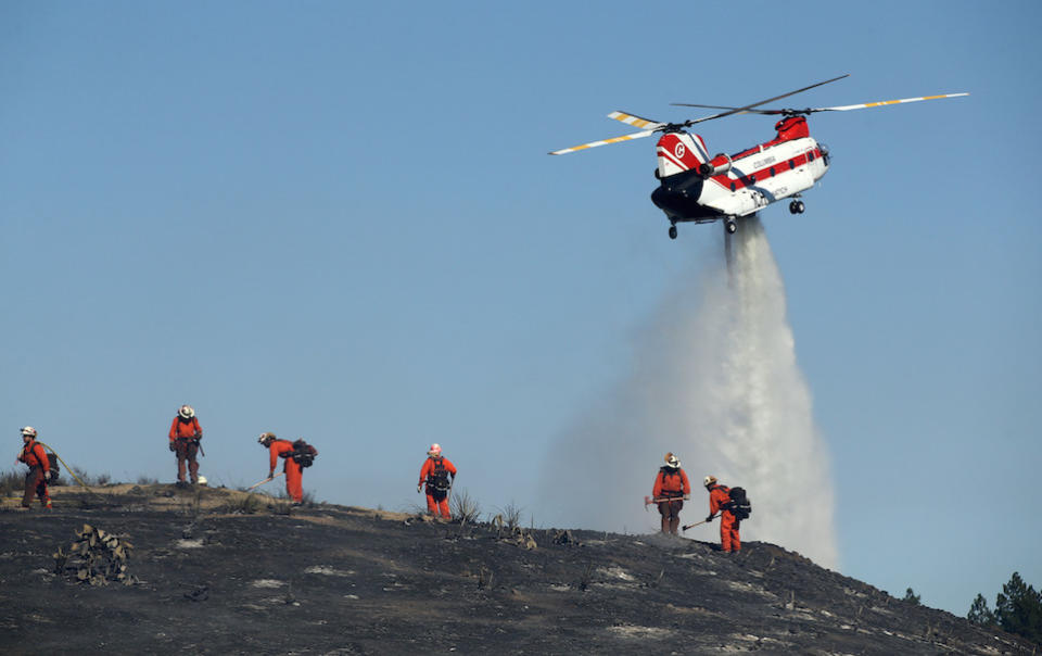 Firefighters put out hotspots as the Hill Fire burned in a canyon in Thousand Oaks, California (Picture: PA)