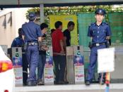 Policemen stand by the entrance to a foreign workers' dormitory in Singapore on November 26. More than 100 mainland Chinese bus drivers in Singapore refused to work in a rare case of labour mass action in the city-state