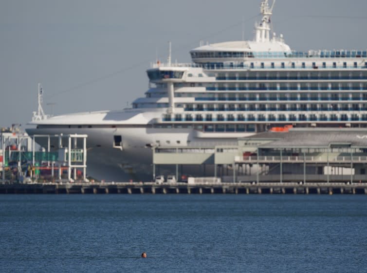 Mandatory Credit: Photo by MICHAEL DODGE/EPA-EFE/Shutterstock (10600979g) A swimmer is seen in front of the Pacific Princess cruise ship at South Melbourne beach in Melbourne, Australia, 03 April 2020. The upcoming weekend in Victoria state will see harsher social distancing laws implemented, such as a ban on all but the most basic outdoor activities. Daily life amid coronavirus pandemic, in Melbourne, Australia - 03 Apr 2020