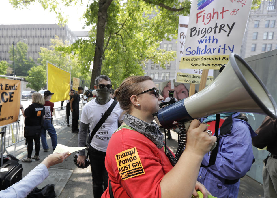 A protester carries a bullhorn while marching on the side of the street of anti-fascist groups counter-protesting as members of Patriot Prayer and other groups supporting gun rights demonstrate across the street during a rally, Saturday, Aug. 18, 2018, at City Hall in Seattle. (AP Photo/Ted S. Warren)