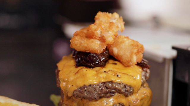 3 layered burger with tatter tots served with fries