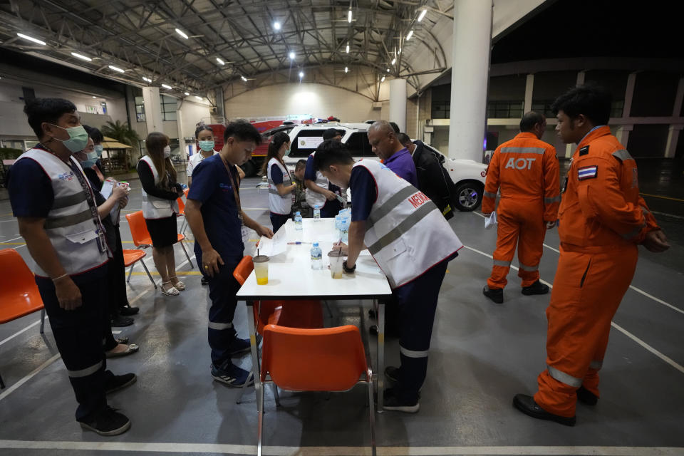 Members of a rescue team discuss after a London-Singapore flight was diverted to Bangkok due to severe turbulence, in Bangkok, Thailand, Tuesday, May 21, 2024. The plane apparently plummeted for a number of minutes before it was diverted to Bangkok, where emergency crews rushed to help injured passengers amid stormy weather, Singapore Airlines said Tuesday. (AP Photo/Sakchai Lalit)