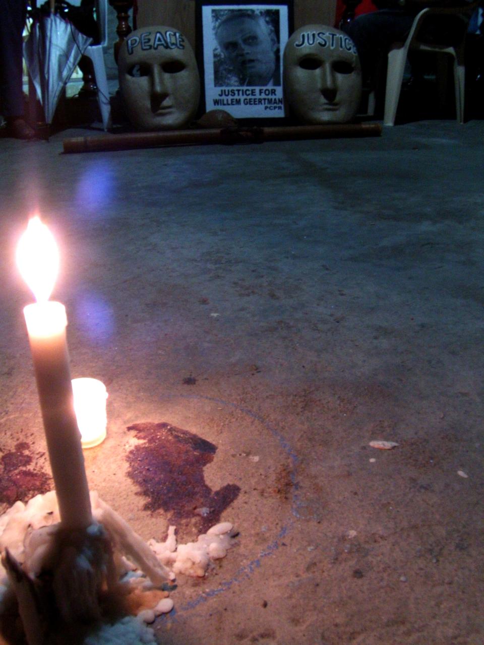 FILE - In this July 6, 2012 file photo, candles are lit at the very spot where Dutch environmental activist Wilhem Geertman, a former religious missionary who helped poor farmers affected by illegal logging and mining, was killed allegedly in a robbery attempt in San Fernando city, Pampanga province, north of Manila, Philippines. A survey released Tuesday, April 15, 2014 - the first comprehensive one of its kind – says that only 10 killers of 908 environmental activists slain around the world over the past decade have been convicted. (AP Photo/Sylwyn Sheen Alba, File)