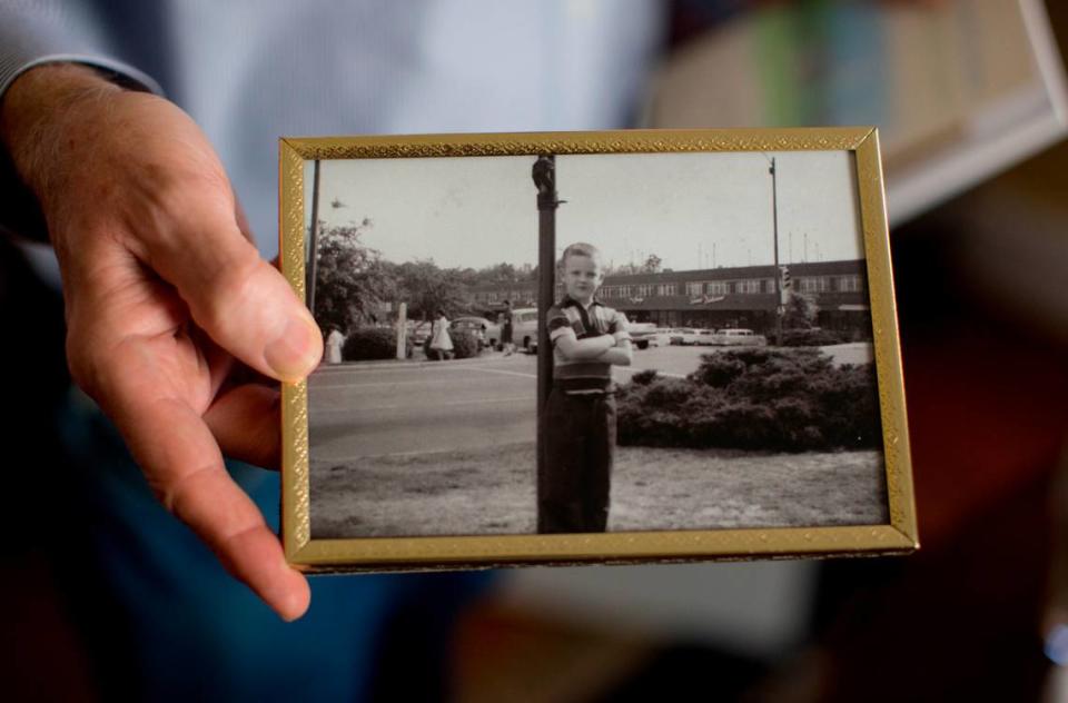 In this November 2014 file photo Myrick Howard, president of Preservation North Carolina, holds a photo of himself that was taken in 1959 in Cameron Village.