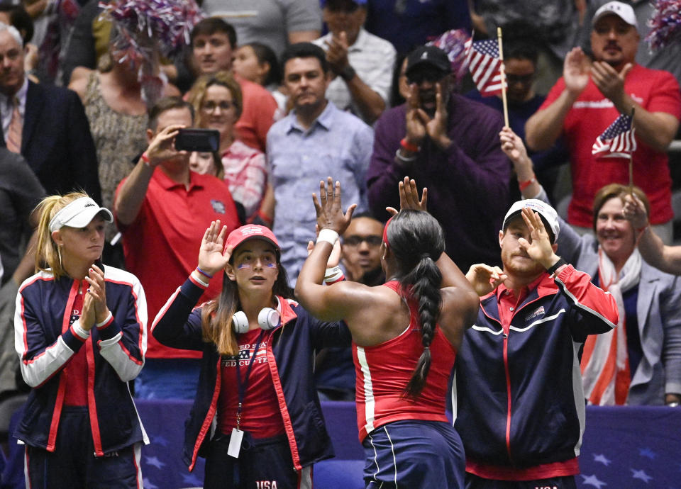 United States' Sloane Stephens, front, high-fives fans after beating Switzerland's Viktorija Golubic during their playoff-round Fed Cup tennis match, Sunday, April 21, 2019, in San Antonio. (AP Photo/Darren Abate)