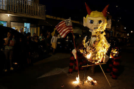 A pinata representing U.S. President-elect Donald Trump as a devil burns during the traditional Burning of the Devil festival, ahead of Christmas in Guatemala City, Guatemala December 7, 2016. REUTERS/Luis Echeverria