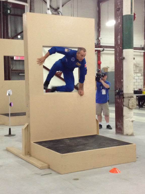 Canadian astronaut David Saint-Jacques leaps through an obstacle at Defence Research and Development Canada as part of an astronaut race in Toronto, Sept. 30, 2014.