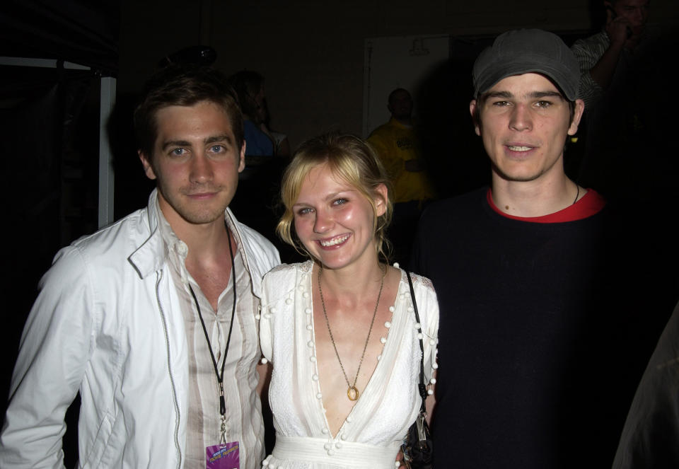 Jake Gyllenhaal, Kirsten Dunst and Josh Hartnett stand smiling backstage at an industry event