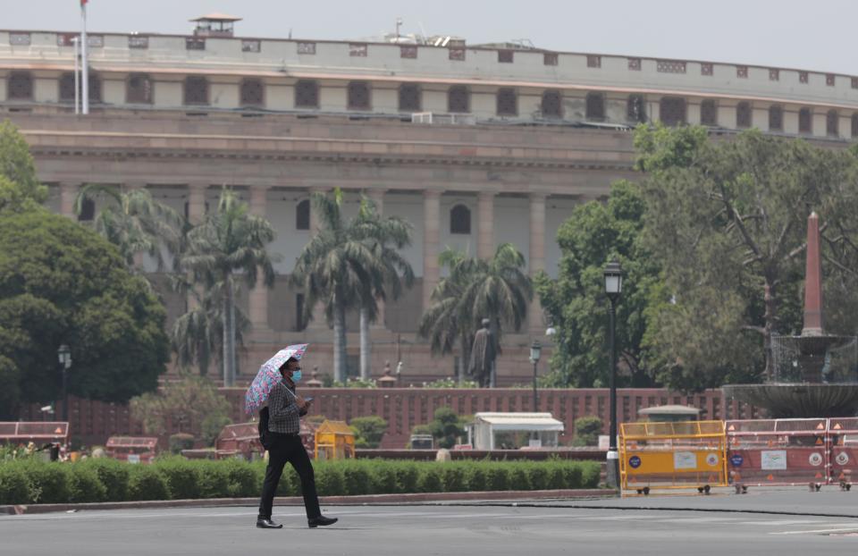 An Indian man carries an umbrella to avoid heat waves as the temperature rises in New Delhi, 28 April 2022 (EPA)