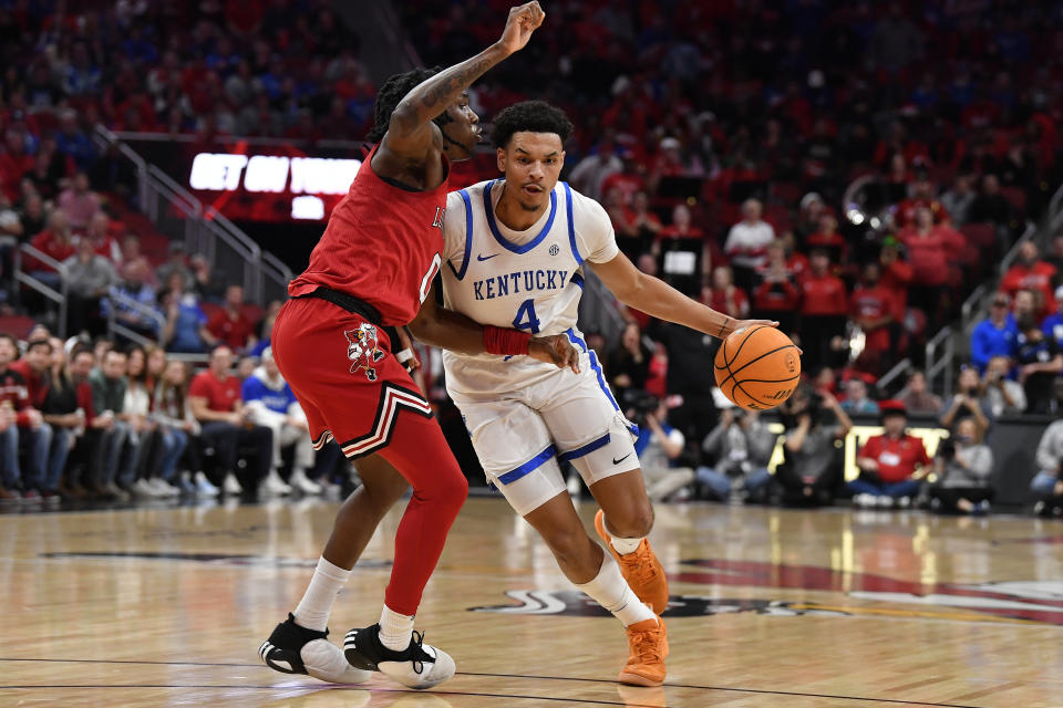 Kentucky forward Tre Mitchell (4) drives to the basket against Louisville guard Mike James (0) during the first half of an NCAA college basketball game in Louisville, Ky., Thursday, Dec. 21, 2023. (AP Photo/Timothy D. Easley)