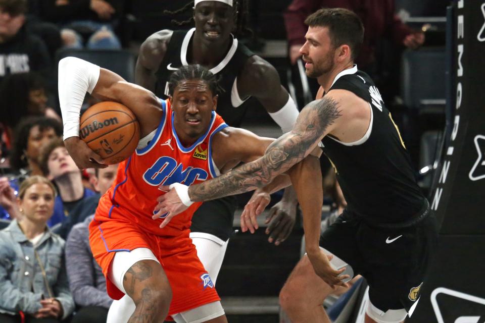 Thunder forward Jalen Williams (8) and Grizzlies guard John Konchar (46) battle for a rebound during the first half of Saturday's game at FedExForum in Memphis, Tenn.