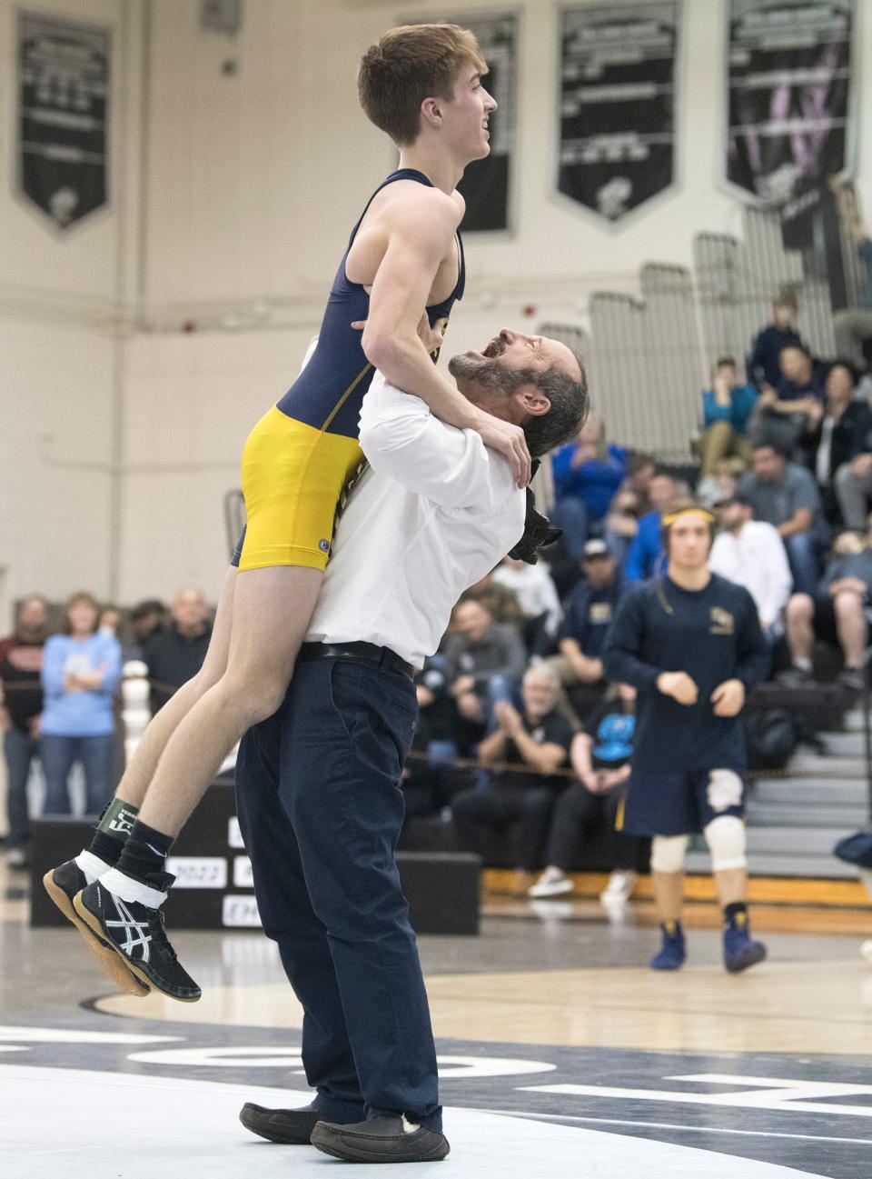 Holy Spirit's Carter Pack celebrates with Holy Spirit's wrestling coach Ralph Paolone after Pack defeated Kingsway's Jason Meola, 7-3, in the 106-pound final of the Region 8 wrestling championships at Egg Harbor Township High School, Saturday, Feb. 26, 2022.