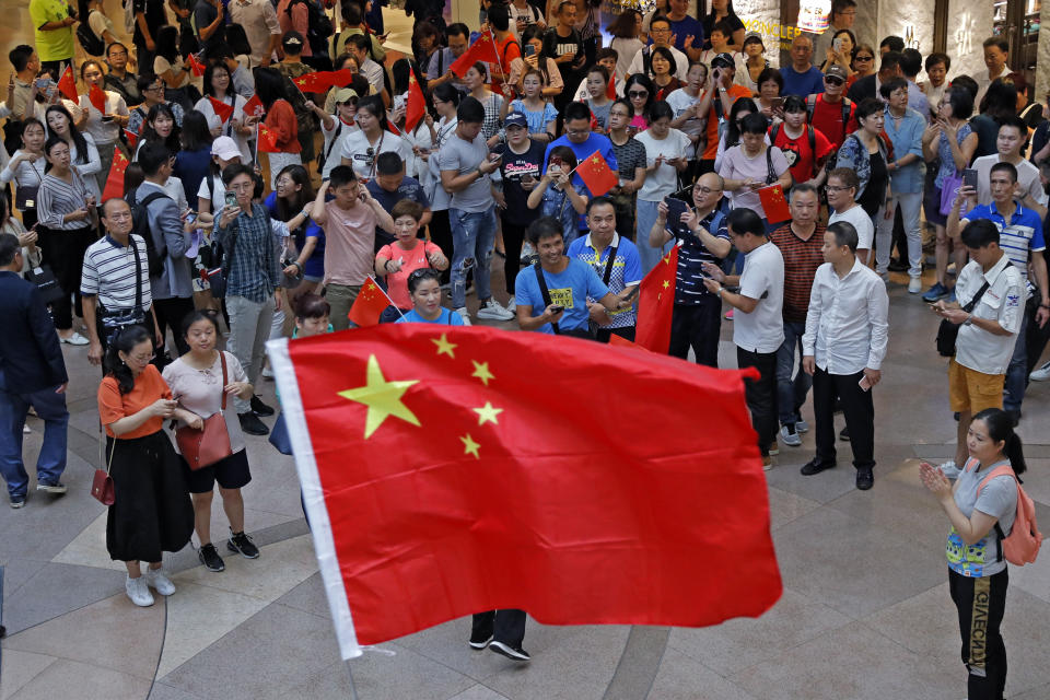 Pro-China supporters wave Chinese national flags in a shopping mall in Hong Kong, Wednesday, Sept. 18, 2019. Activists involved in the pro-democracy protests in Hong Kong appealed to U.S. lawmakers Tuesday to support their fight by banning the export of American police equipment that is used against demonstrators and by more closely monitoring Chinese efforts to undermine civil liberties in the city. (AP Photo/Kin Cheung)