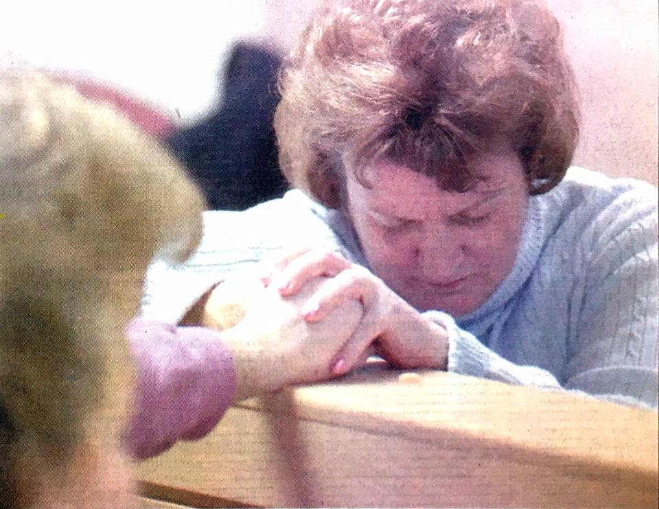Karen Boes holds hands with supporters in 2003 just before the reading of a guilty verdict at the Ottawa County Circuit Court in Grand Haven. Boes maintains she's innocent.