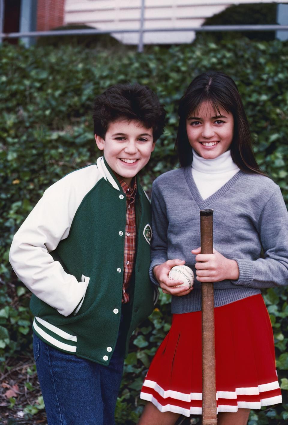 A throwback promo photo of Winnie on the right and Fred Savage on the left. They're standing outside wearing baseball-inspired outfits