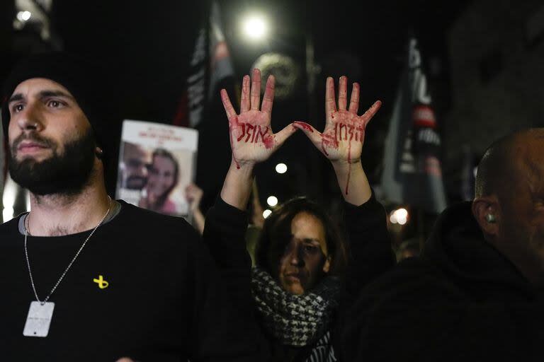 Familiares de los rehenes israelíes retenidos en Gaza por Hamas asisten a una protesta pidiendo su liberación. En hebreo, en las manos con sangre falsa se lee “El tiempo se acaba”. (Ohad Zwigenberg)