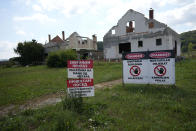 A sign saying "Access forbidden to unauthorized persons" is displayed in front of a house bought by Rio Tinto company in the village of Gornje Nedeljice, in the fertile Jadar Valley in western Serbia, Tuesday, Aug. 6, 2024. (AP Photo/Darko Vojinovic)