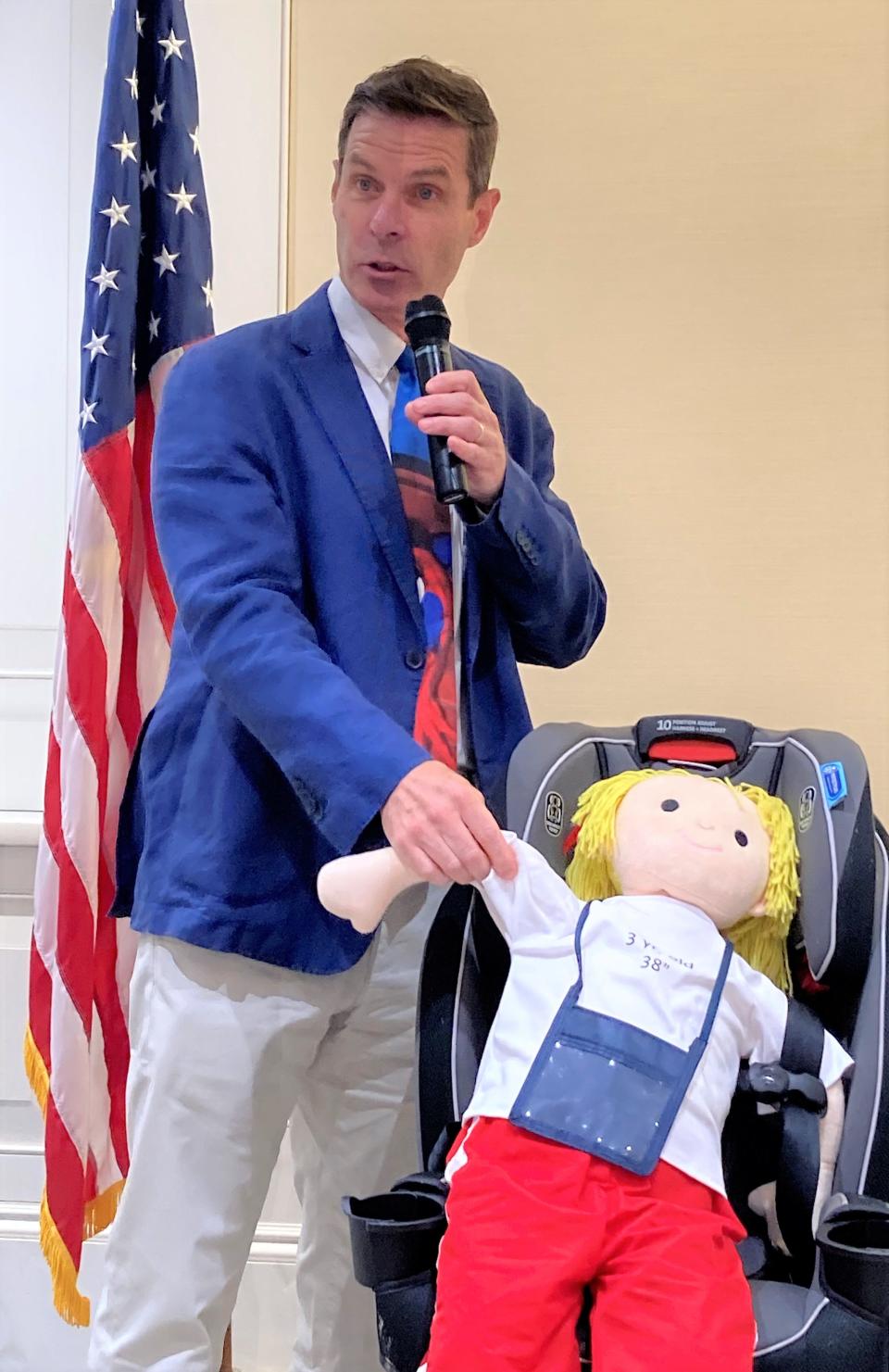 Dr. Gregory Parkinson, a Cape Cod pediatrician, demonstrates on the doll Molly, 3, what happens in a car crash during a legislative briefing Wednesday, urging lawmakers to pass the update to the child restraint laws and save little lives.