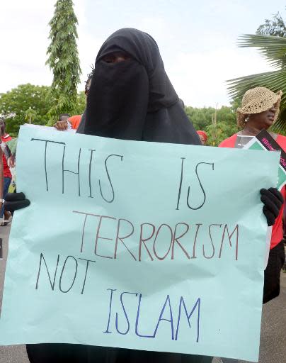 Una mujer vestida con un burka sostiene una pancarta en la que se puede leer 'Esto es terrorismo no es Islam' en una manifestación en favor de la liberación de las 276 estudiantes secuestradas por Boko Haram, en Lagos, Nigeria, el 5 de mayo de 2014 (AFP | Pius Utomi Ekpei)