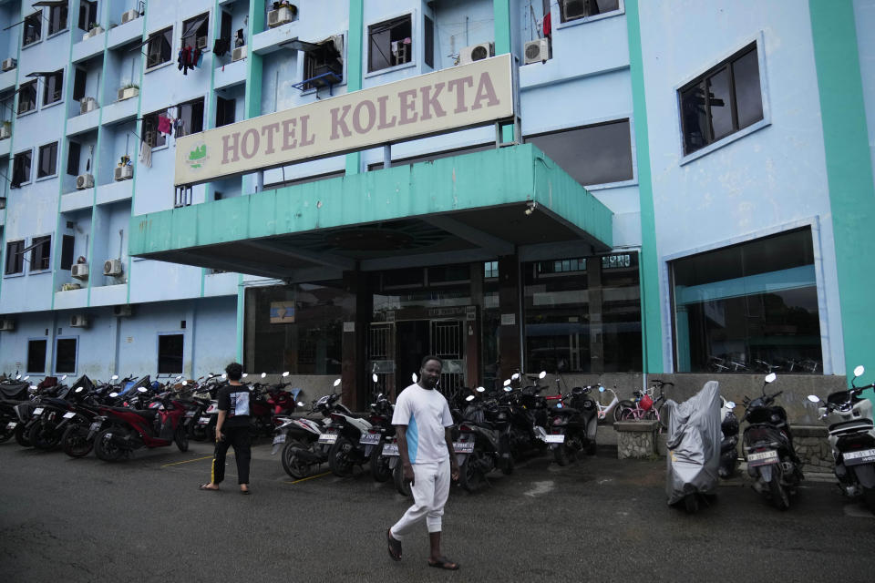 Refugees walk outside Hotel Kolekta, turned into a shelter for refugees, in Batam, an island in northwestern Indonesia, Thursday, May 16, 2024. The former tourist hotel was converted in 2015 into a temporary shelter that today houses 228 refugees from conflict-torn nations including Afghanistan, Somalia, Sudan and elsewhere. (AP Photo/Dita Alangkara)
