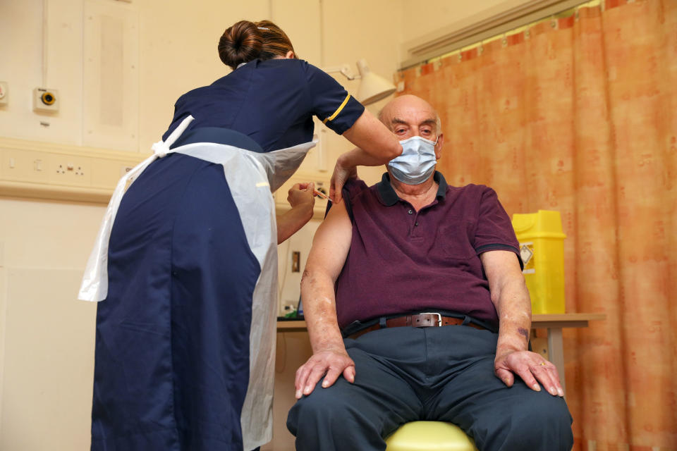 OXFORD, ENGLAND - JANUARY 04 82-year-old Brian Pinker receives the Oxford University/AstraZeneca COVID-19 vaccine from nurse Sam Foster at the Churchill Hospital in Oxford as the NHS increases its vaccination programme with 530,000 doses of the newly approved jab available for rollout across the UK on January 4, 2021 in Oxford, England.  (Photo by Steve Parsons - WPA Pool/Getty Images)