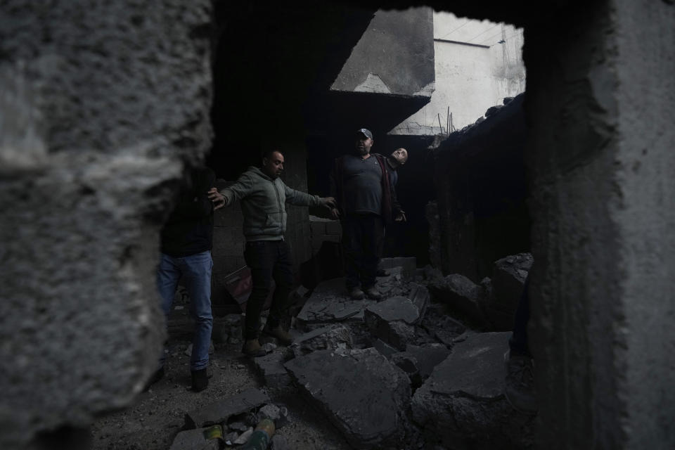 Palestinians inspect the site of a damaged building following an Israeli forces raid in the West Bank city of Jenin, Tuesday, March 7, 2023. The Israeli army has raided the occupied West Bank city of Jenin, leading to a gunbattle that killed at least six Palestinians, Israeli officials said the target of the raid was a militant who killed two Israeli brothers in a West Bank shooting last week. The man was among those killed on Tuesday. (AP Photo/Majdi Mohammed)