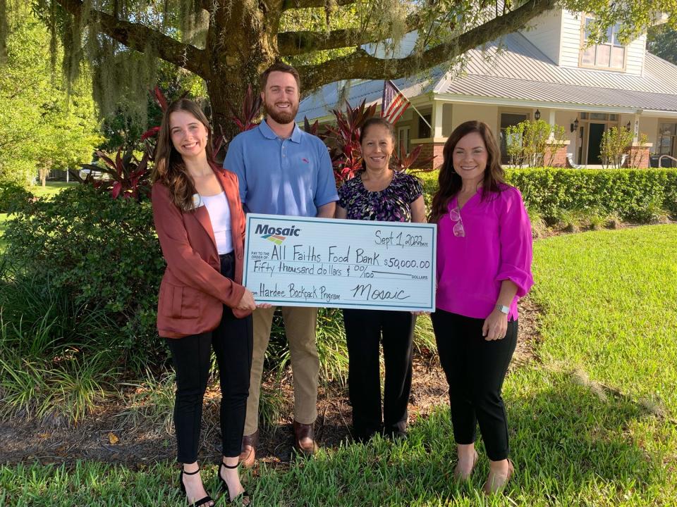 Isabelle Ball, left, of All Faiths Food Bank, and Mosaic Co. employees Carson Ciavardone, Joann Garza and Heather Nedley take part in a check presentation in support of the Backpack program in Hardee County.