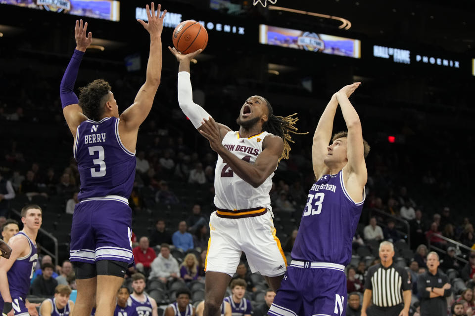 Arizona State forward Bryant Selebangue (24) drives between Northwestern guard Ty Berry (3) and forward Luke Hunger during the first half of an NCAA college basketball game Wednesday, Dec. 20, 2023, in Phoenix. (AP Photo/Rick Scuteri)