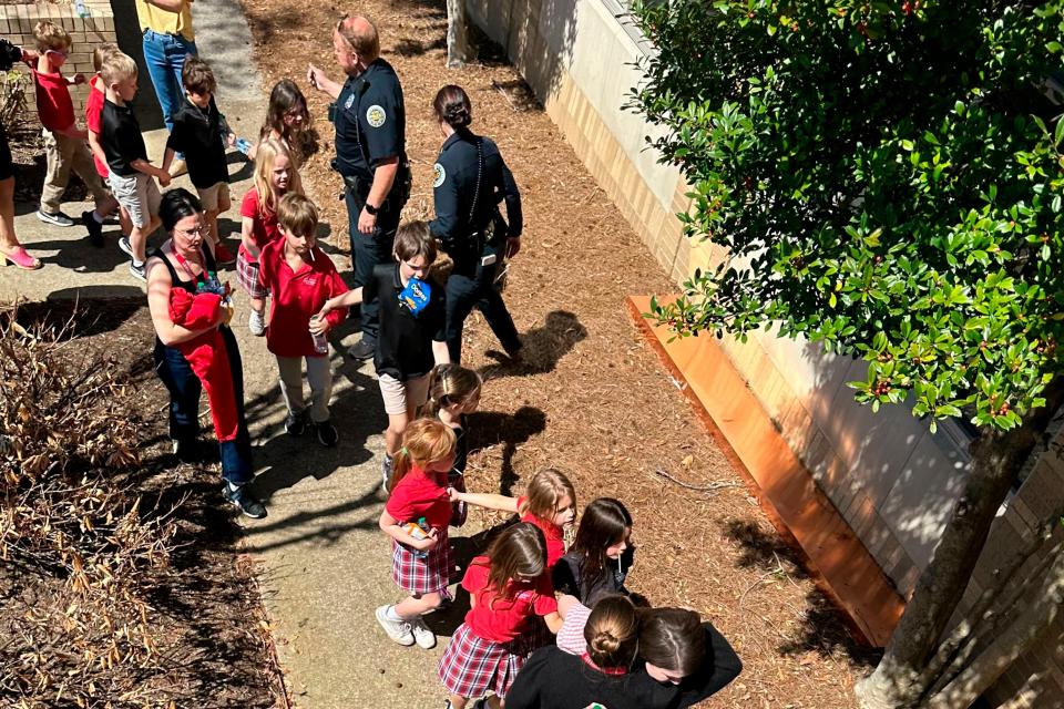 Children from The Covenant School, a private Christian school in Nashville, Tenn., hold hands as they are taken to a reunification site at the Woodmont Baptist Church after a shooting at their school, on Monday, March, 27, 2023. (George Uribe via AP) (AP)