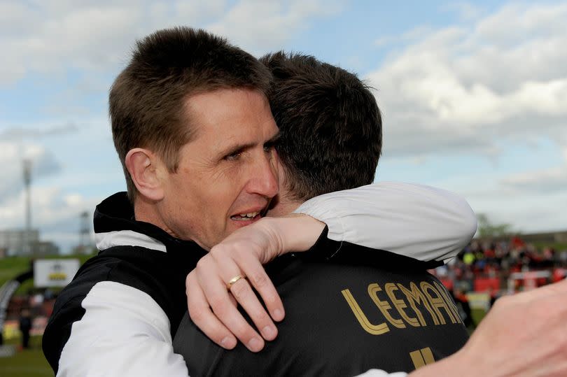 Photo showing Crusaders manager Stephen Baxter celebrating with Paul Leeman following their 2012 Setanta Cup win over Derry City