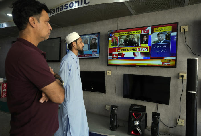 People watch a TV news report about the death of former Pakistani President Gen. Pervez Musharraf at a TV shop in Karachi, Pakistan, Sunday, Feb. 5, 2023. Musharraf, who seized power in a bloodless coup and later led a reluctant Pakistan into aiding the U.S. war in Afghanistan against the Taliban, has died, officials said Sunday. He was 79. (AP Photo/Fareed Khan)